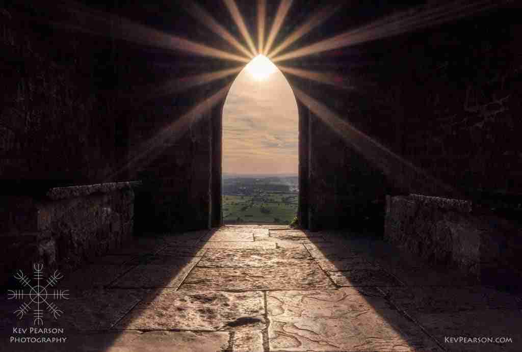 Divine Light by Kev Pearson. The sun trhought the archway of the tower on Glastonbury Tor.