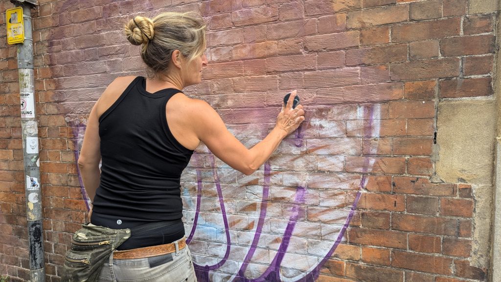 Kim cleaning up grafitti
